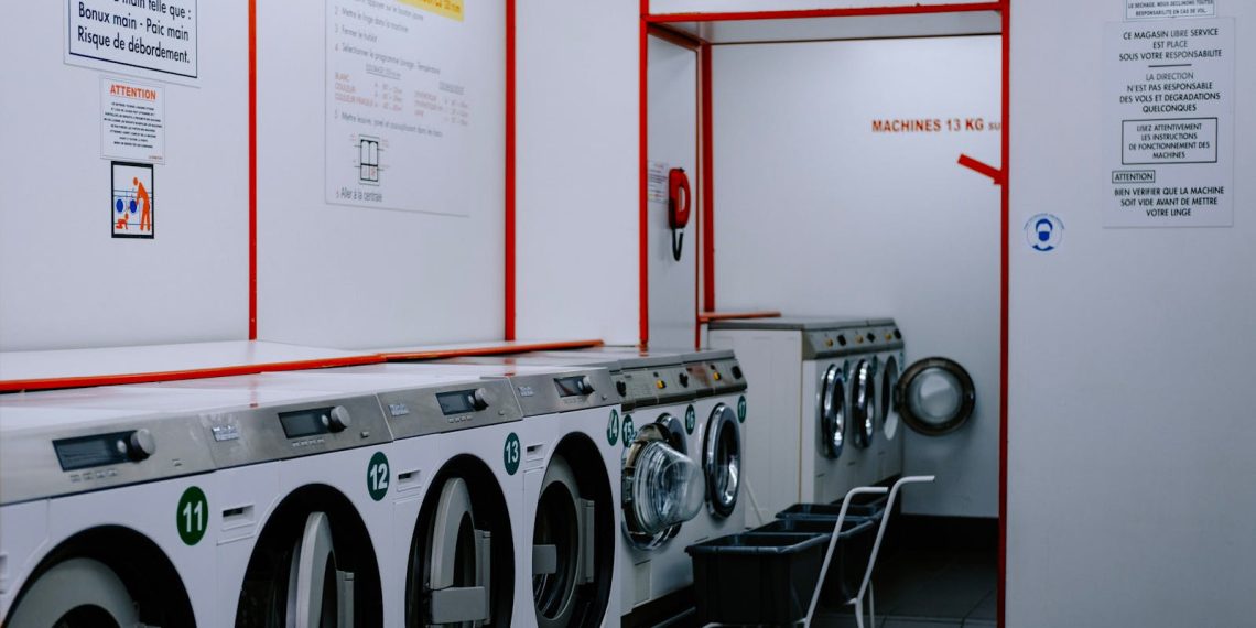 Industrial Washing Machines Lined up Under Wall