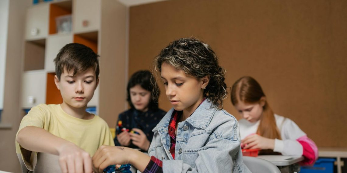 Children Putting Parts of a Robotics Device Together